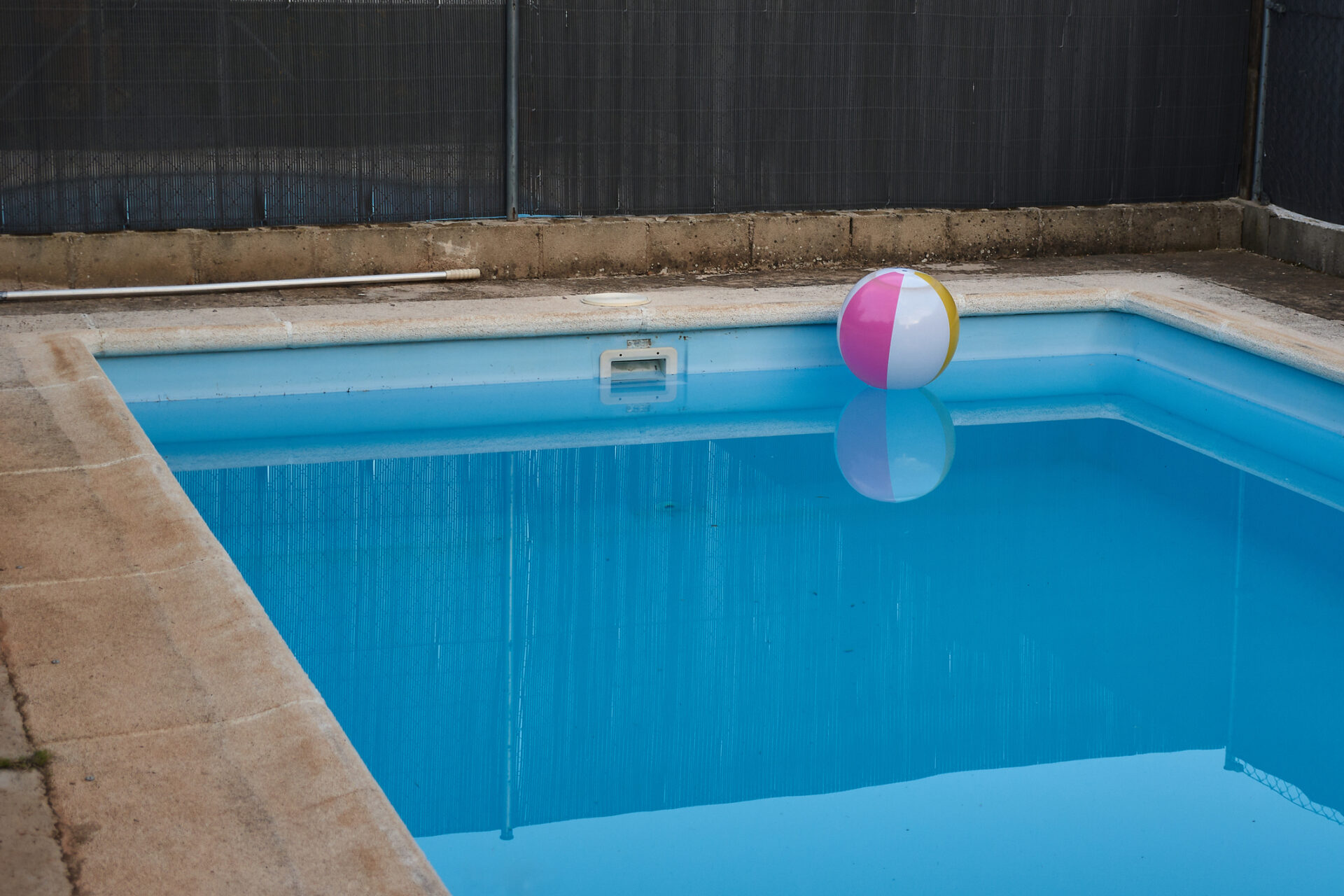 a lonely private pool in the shade at the end of summer.