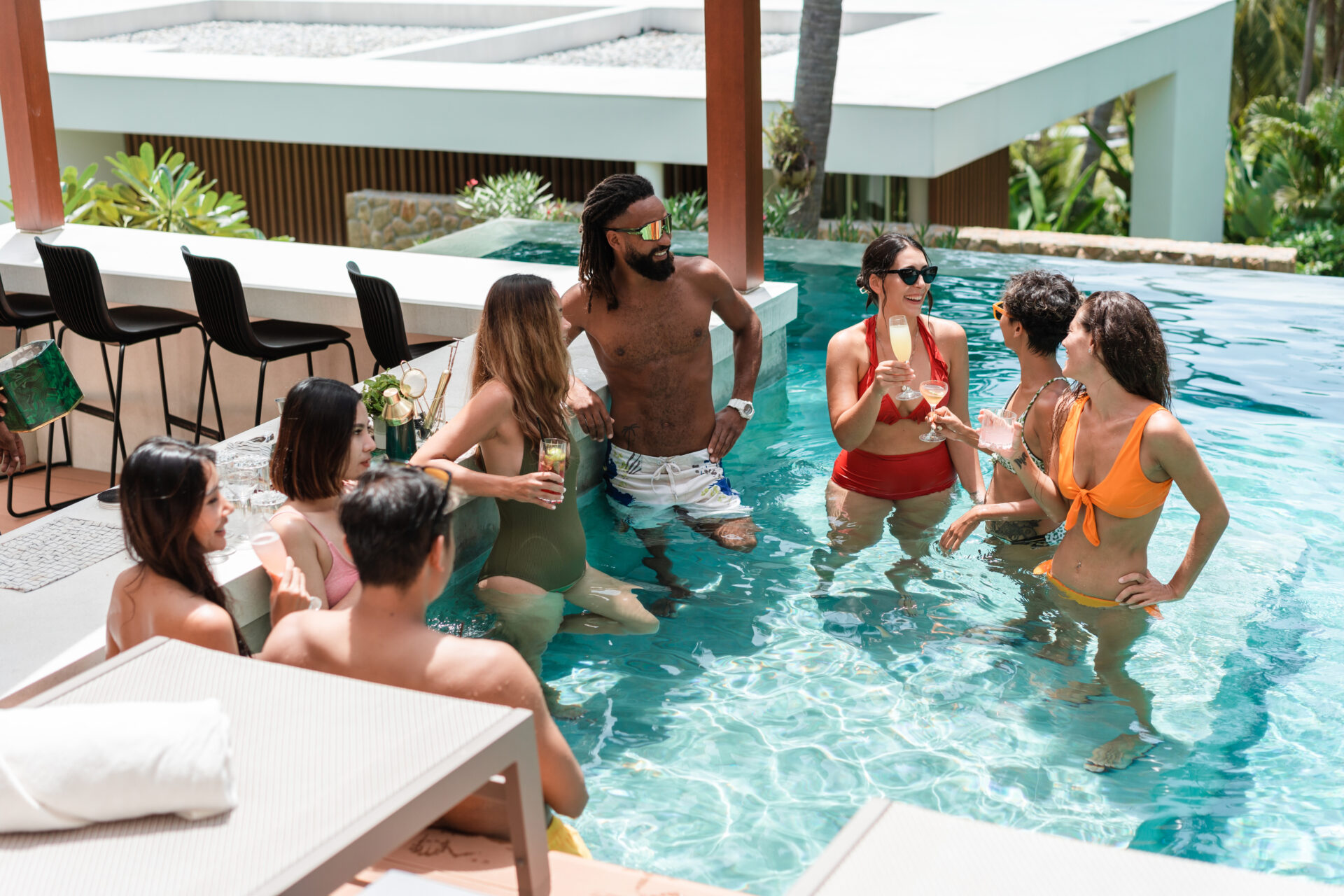 Multiracial group of people is having fun at the pool party on their vacation in a luxury villa.